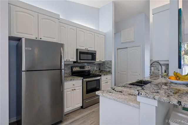 kitchen with appliances with stainless steel finishes, white cabinetry, and sink