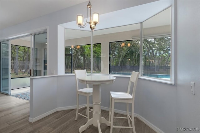 dining room with hardwood / wood-style flooring and an inviting chandelier