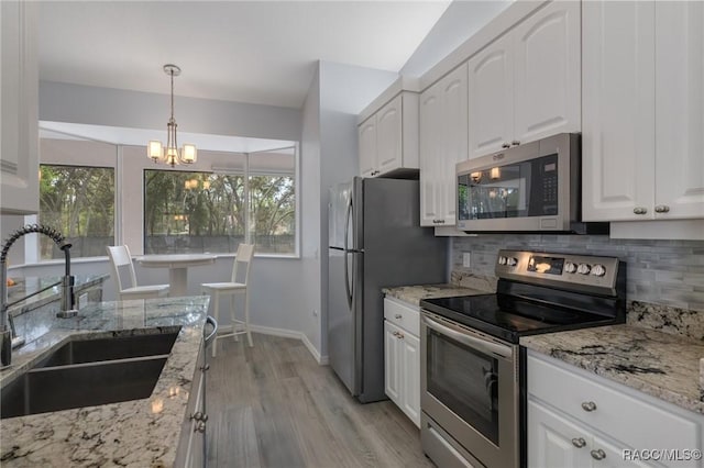 kitchen with white cabinetry, stainless steel appliances, sink, tasteful backsplash, and pendant lighting