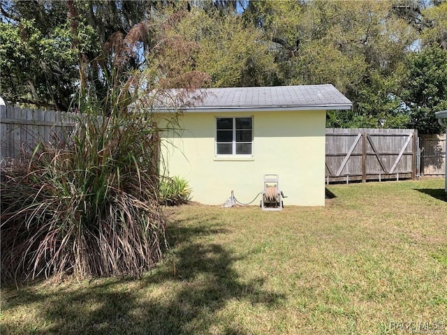 view of outbuilding featuring fence and a gate