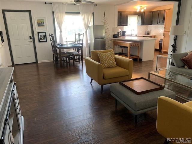 living room featuring baseboards, a ceiling fan, and dark wood-style flooring