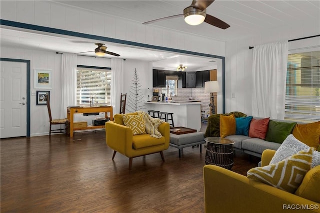 living area featuring dark wood-type flooring and a ceiling fan