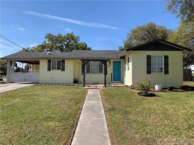 view of front of property with driveway, stucco siding, a carport, and a front yard