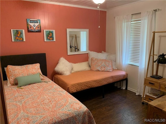 bedroom with ornamental molding and dark wood-type flooring