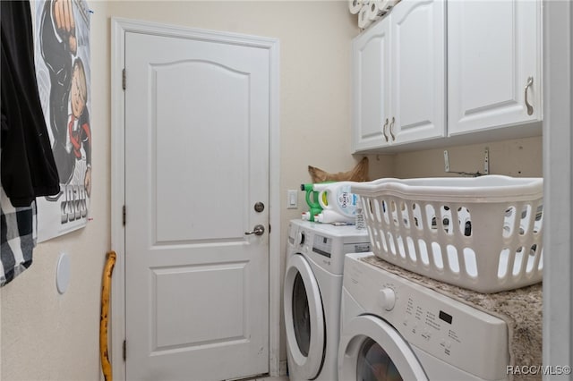 laundry room with washer and dryer and cabinets