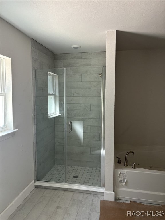 bathroom with hardwood / wood-style floors and independent shower and bath