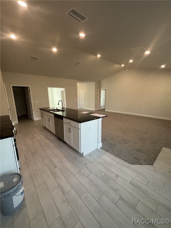 kitchen featuring lofted ceiling, sink, dishwasher, an island with sink, and white cabinets