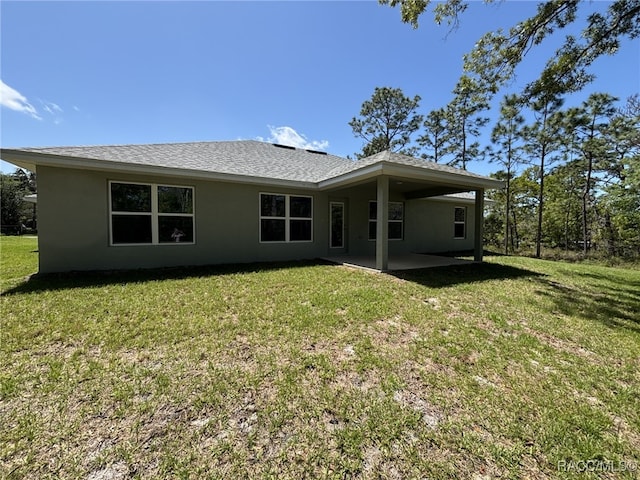 2400 W Tall Oaks Dr, Beverly Hills, FL 34465 - rear view of house with stucco siding, a patio area, and a lawn