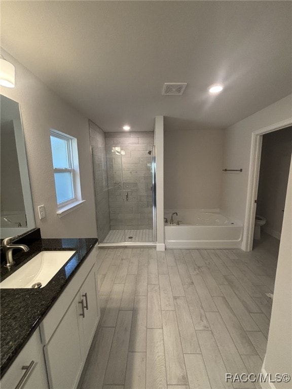 full bathroom featuring vanity, plus walk in shower, and toilet