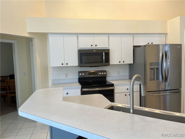 kitchen featuring white cabinets, stainless steel appliances, and light countertops