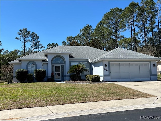 ranch-style home with driveway, a front lawn, and stucco siding