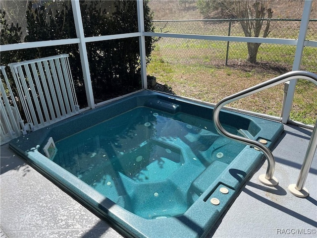 view of swimming pool featuring an outdoor hot tub and fence