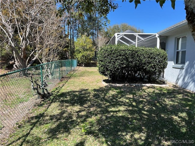 view of yard with glass enclosure and a fenced backyard