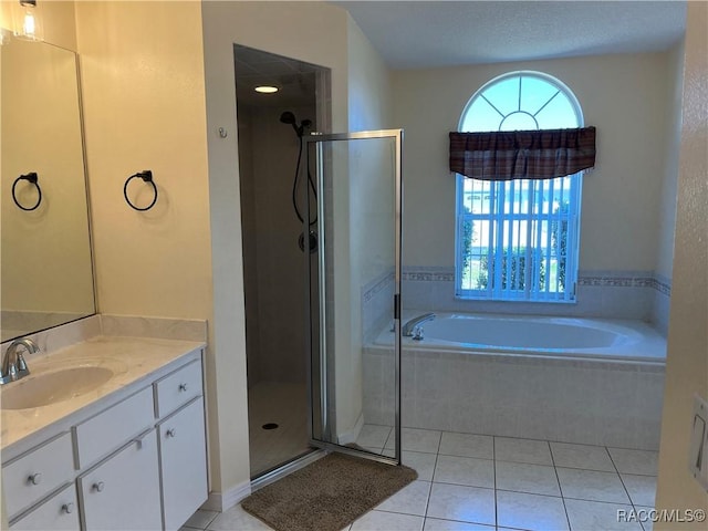 full bath with a stall shower, tile patterned floors, a bath, and vanity