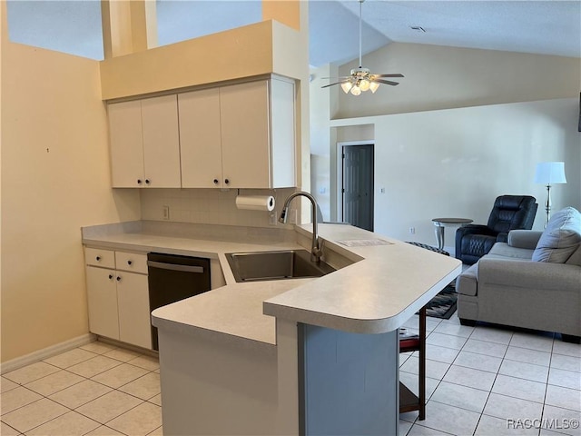 kitchen with a peninsula, a sink, white cabinetry, open floor plan, and a kitchen bar