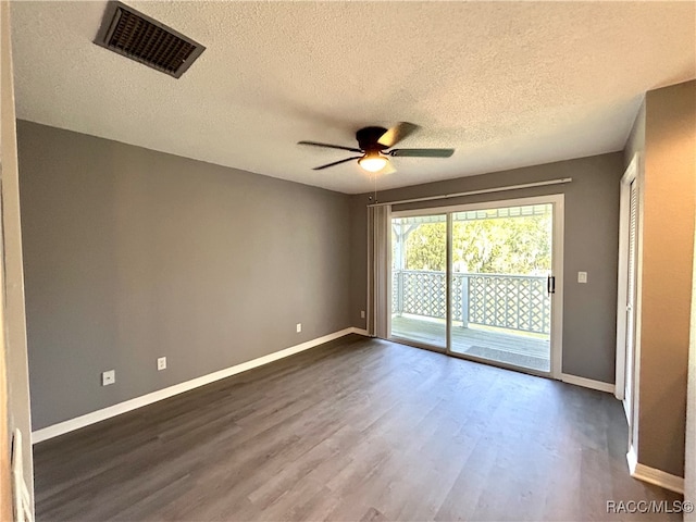 unfurnished room featuring a textured ceiling, dark hardwood / wood-style floors, and ceiling fan