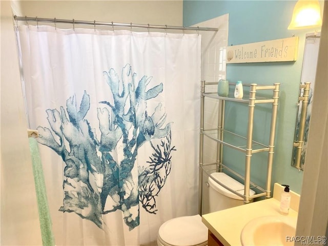 bathroom featuring toilet, vanity, and a shower with shower curtain