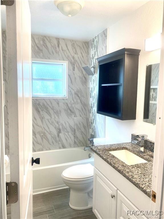 full bathroom featuring toilet, tiled shower / bath, and vanity