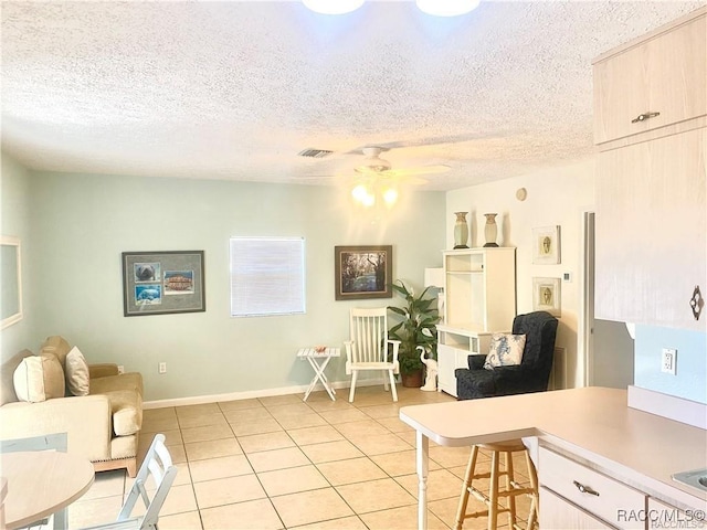 tiled living room featuring a textured ceiling and ceiling fan