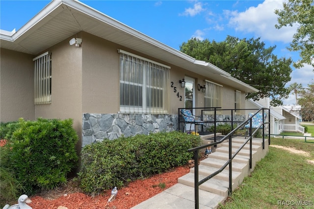 exterior space featuring stone siding and stucco siding