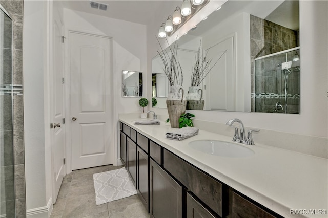 bathroom with tile patterned flooring, vanity, and a shower with shower door