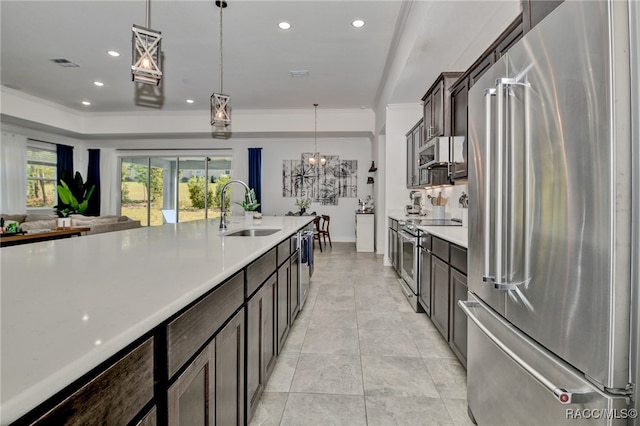 kitchen featuring pendant lighting, an inviting chandelier, sink, dark brown cabinets, and stainless steel appliances