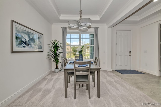 dining area featuring light carpet, a tray ceiling, and crown molding