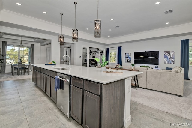 kitchen with a kitchen island with sink, crown molding, sink, hanging light fixtures, and dark brown cabinetry