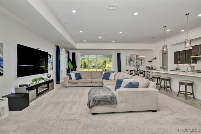 carpeted living room featuring ornamental molding and a notable chandelier