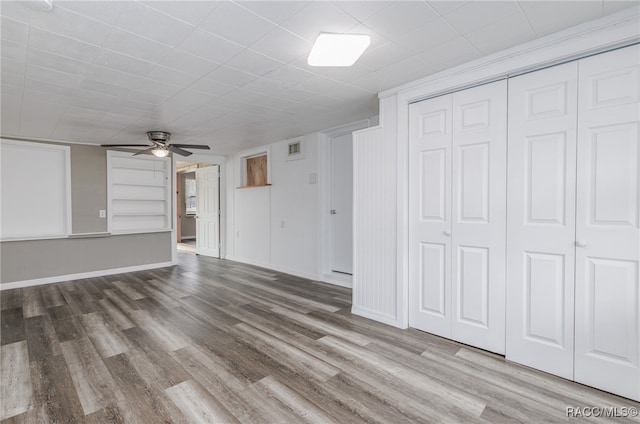 unfurnished living room featuring ceiling fan and wood-type flooring