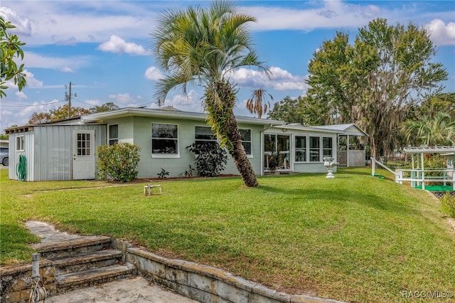 back of house with a sunroom and a yard