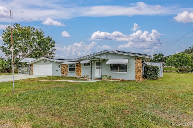 single story home featuring solar panels, a garage, and a front lawn