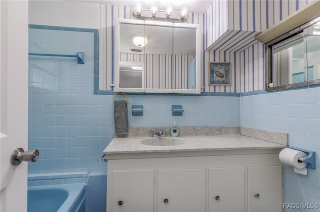 bathroom featuring vanity, tile walls, and a bathing tub