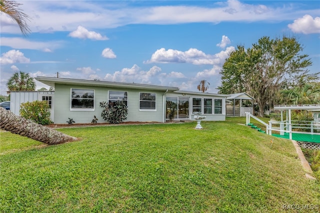 back of house featuring a lawn and a sunroom