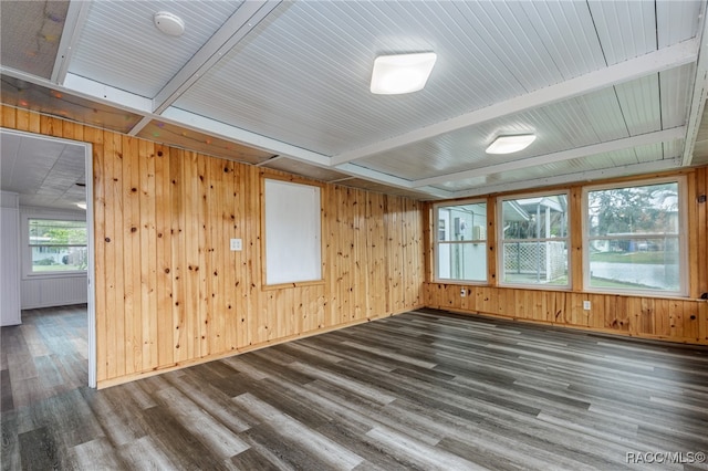 unfurnished room with beam ceiling, dark hardwood / wood-style flooring, and wooden walls