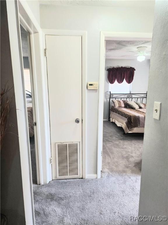 hallway featuring visible vents and carpet floors