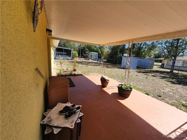 view of patio / terrace featuring a storage shed, an outdoor structure, and fence