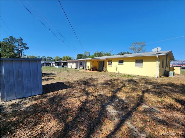 rear view of property featuring stucco siding and cooling unit