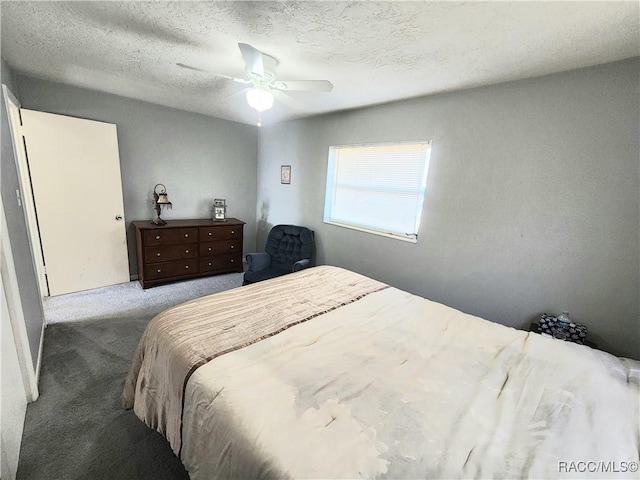 carpeted bedroom featuring ceiling fan and a textured ceiling