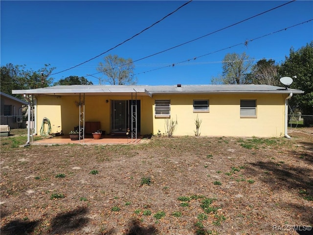 back of house with a patio, fence, and stucco siding