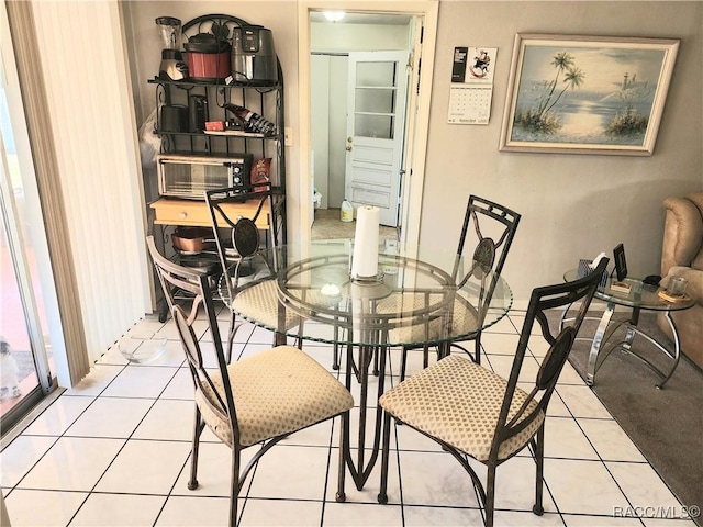 dining area featuring tile patterned floors and a toaster