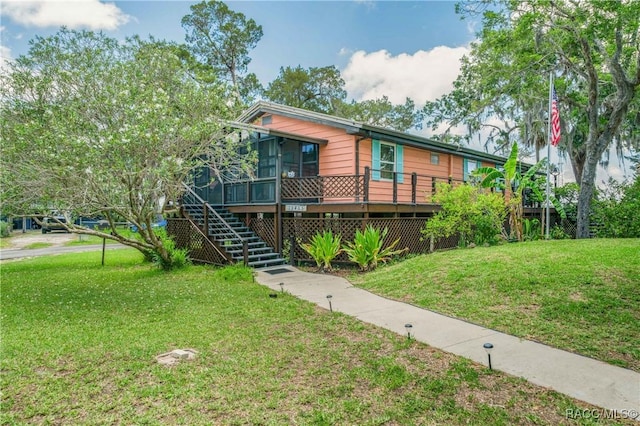 13465 W Hillbilly Ln, Crystal River, FL 34429 - view of front of property with a front lawn, stairs, a deck, and a sunroom