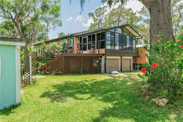 13465 W Hillbilly Ln, Crystal River, FL 34429 - rear view of property with stairs, an attached garage, a yard, a sunroom, and a deck