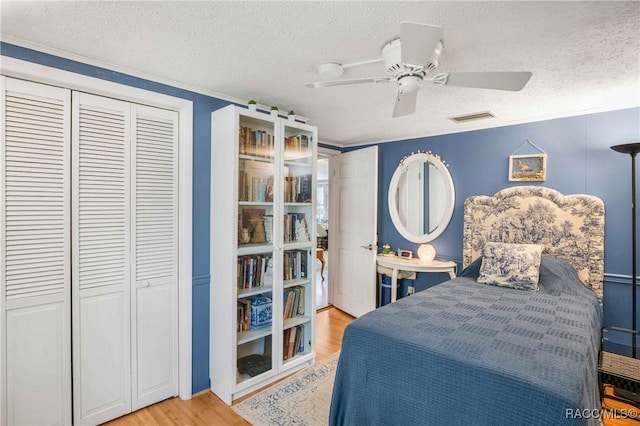13465 W Hillbilly Ln, Crystal River, FL 34429 - bedroom with a textured ceiling, light wood-type flooring, a ceiling fan, and a closet