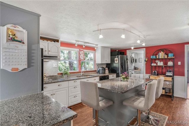 13465 W Hillbilly Ln, Crystal River, FL 34429 - kitchen featuring stainless steel refrigerator with ice dispenser, a sink, wood finished floors, a breakfast bar, and white cabinetry
