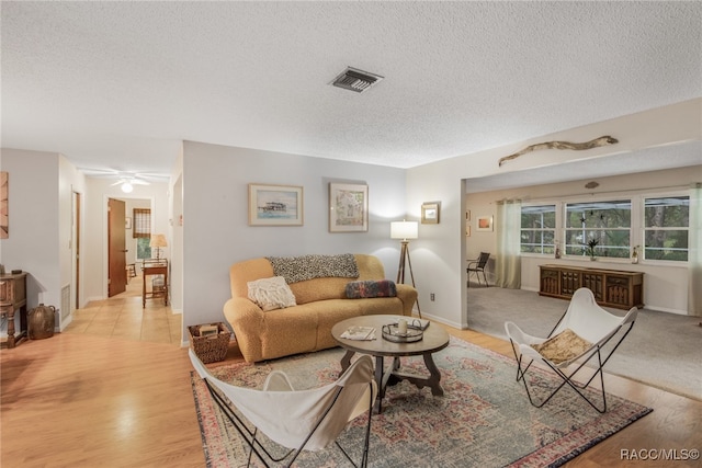 living room with a textured ceiling and light hardwood / wood-style floors