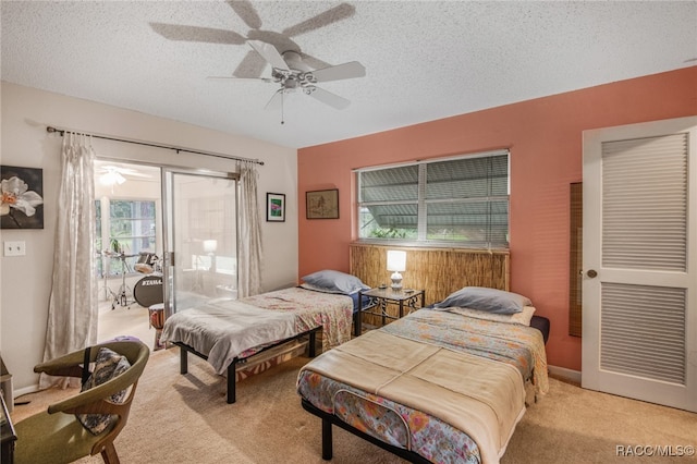 carpeted bedroom featuring multiple windows, a textured ceiling, and ceiling fan