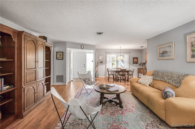 living room featuring a textured ceiling and light wood-type flooring