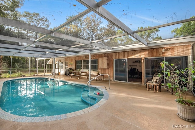 view of swimming pool featuring a lanai and a patio area