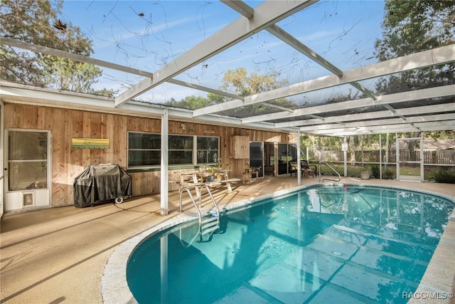 view of pool with a lanai, a grill, and a patio